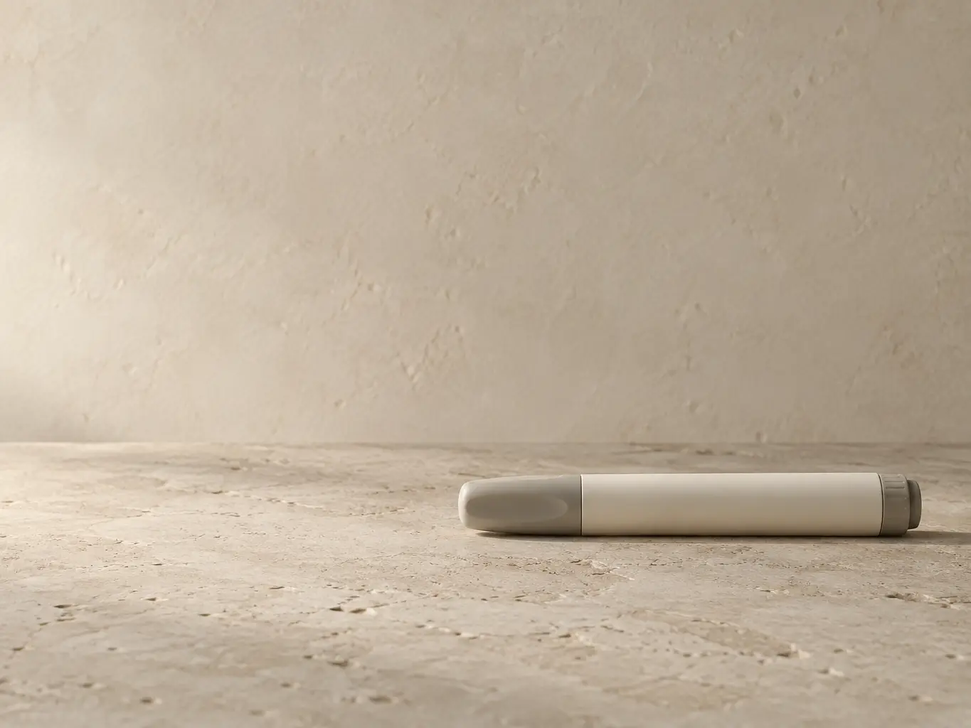 Unbranded injection pen on a warm limestone surface