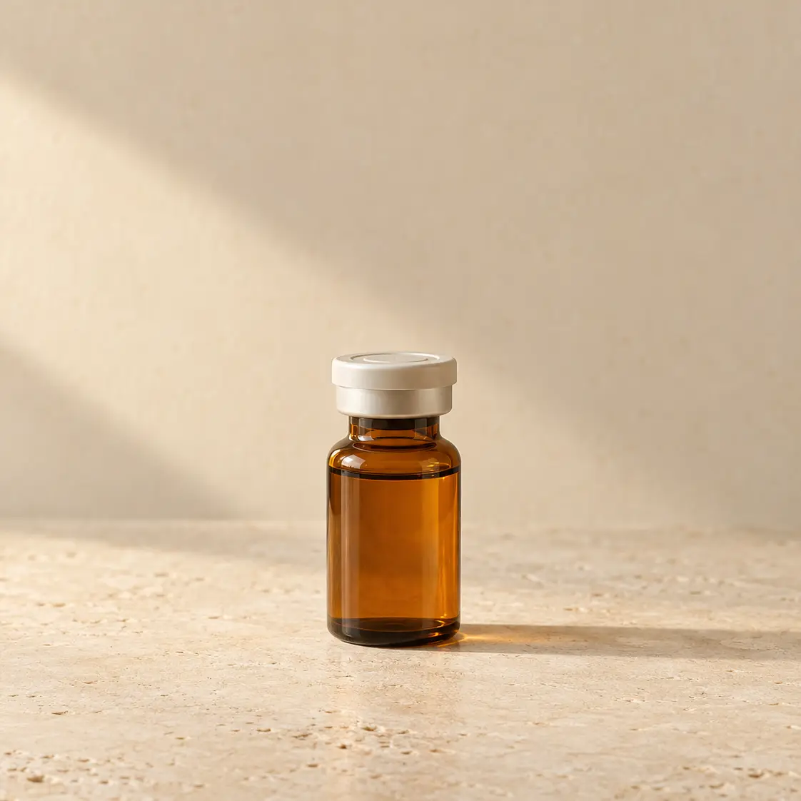 Small amber medication vial on warm limestone